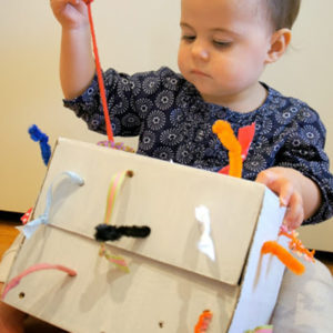 bambino gioca con scatola dei nastri Montessori