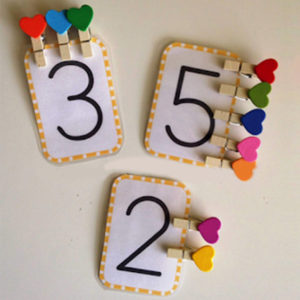 Giochi Montessori per imparare i numeri, mollette a cuore abbinate a tessere numerate